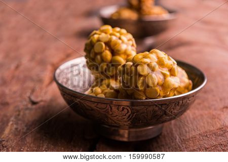Putnala / futana  / Dalia / Roasted Chickpeas sweet Laddu made up of jaggery or gud or gur in hindi, selective focus