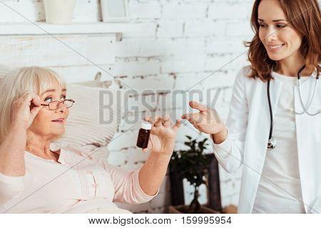 A piece of advice. Pleasant professioanl doctor advicing aged ill woman remedy and talking with her