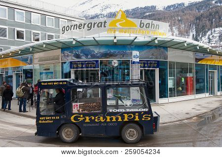 Zermatt, Switzerland - March 04, 2009: Gornergratbahn Train Station With Electric Taxi Passing By In