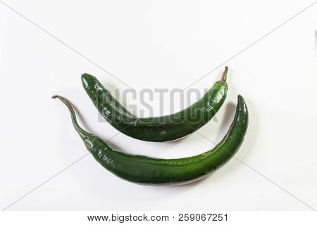 Two Curved Green Chilaca Peppers Nested, Copy Space, Isolated On White, Horizontal Aspect