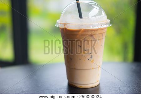 Ice Caramel Mochiato In Takeaway Cup On Black Table