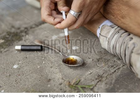 Intravenous Junkie Filling Up A Heroin Syringe Getting Cooked Heroin From A Spoon, Getting His Shoot