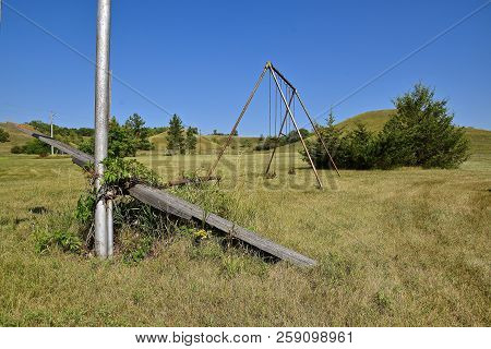 A Swing Set And Teeter-tooter Remain On An Abandoned School Playground