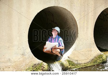 um contratante vistas estampas azuis enquanto em um canteiro de obras