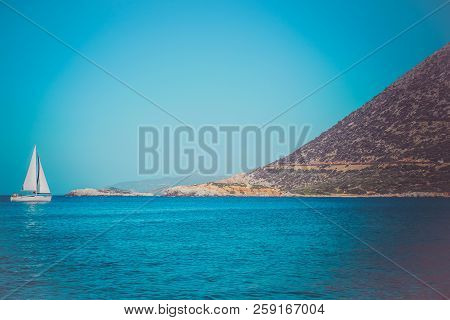 White Sailboat In The Open Mediterranean Sea On A Sunny Day. Sailing Yacht In The Open Sea With Moun