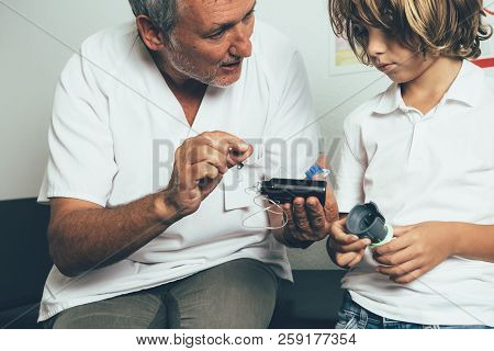 The Pediatric Endocrine Doctor Explaining To A Young Diabetic Patient The Insulin Pump Functions In 