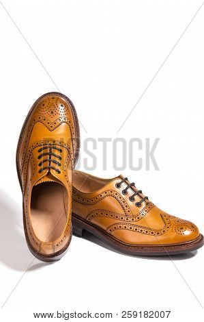 A Pair Of Luxury Male Full Brogued Tan Oxford Shoes. Isolated Over White Background.vertical Composi