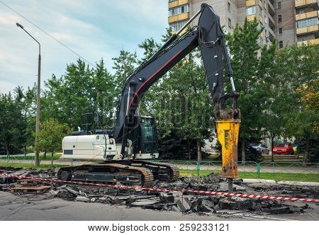 Excavator Breaking Concrete Road Surface With Hydrohammer Drill At Repairing Roadwork. Overhaul Of T