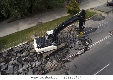 Excavator Breaking Concrete Road Surface With Hydrohammer Drill At Repairing Roadwork. Overhaul Of T