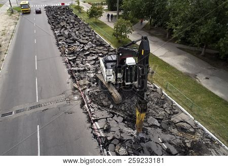 Excavator Breaking Concrete Road Surface With Hydrohammer Drill At Repairing Roadwork. Overhaul Of T