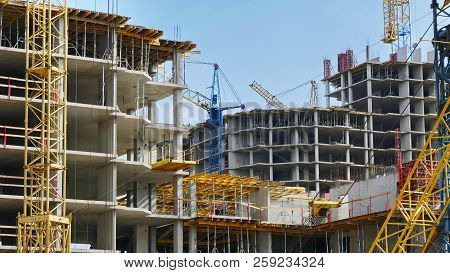 Construction Site Background. Hoisting Cranes And New Multi-storey Buildings. I.ndustrial Background