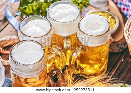 Oktoberfest Beer, Pretzels And Various Bavarian Specialties On Wooden Background