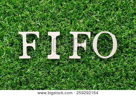 Wood Letter In Word Fifo (abbreviation Of First In First Out) On Artificial Green Grass Background