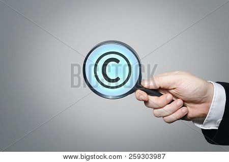 Copyright Symbol Under A Magnifying Glass. Conceptual Image Of Intellectual Property And Copyright.