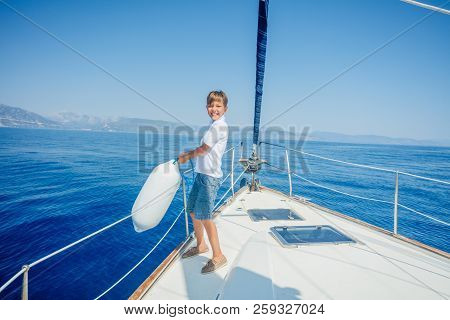 Little Boy On Board Of Sailing Yacht On Summer Cruise.