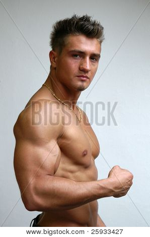 Muscular young model flexing biceps