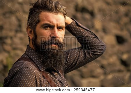 Closeup View Of One Handsome Senior Man With Black Hair And Long Lush Beard In Blue Shirt And Purple