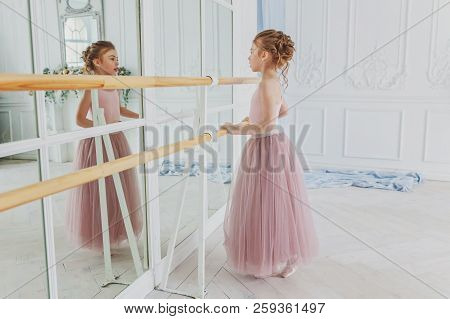 Young Classical Ballet Dancer Girl In Dance Class. Beautiful Graceful Ballerina Practice Ballet Posi