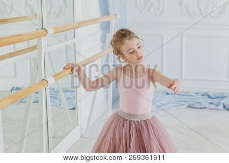Young Classical Ballet Dancer Girl In Dance Class. Beautiful Graceful Ballerina Practice Ballet Posi