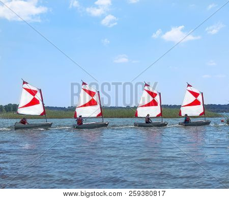 Parentis-en-born, France - July 25, 2018: Four Dinghy With A Red-white Sails On The Lake. Sailboats 