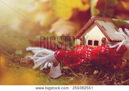Little Toy House Wrapped Scarf In Autumn Forest, Illuminated By Sun, Close-up Photo, Selective Focus