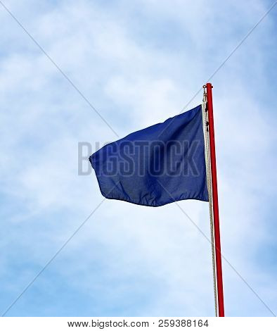 Blue Flag Waves On The Blue Sky. This Is The Symbol Of Not Pollution In This Area