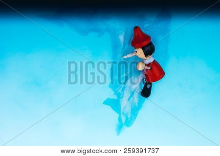 Wodden Puppet Pinocchio On In Blue Water