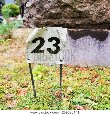 Tin Plate With A Number 23 Sticked Into The Ground.