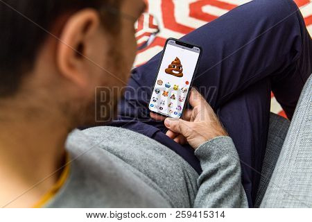 London, Uk - Sep 21, 2018: Man Using The New Pile Of Poo Ar Memoji Emoji Face On Apple Iphone Xs Wit