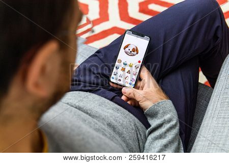 London, Uk - Sep 21, 2018: Man Using The New Smiling Dog Pet Ar Memoji Emoji Face On Apple Iphone Xs
