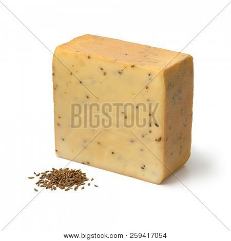 Piece of traditional German caraway cheese and seeds isolated on white background