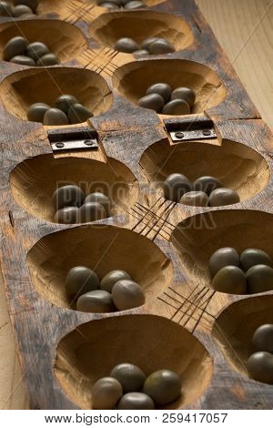 Traditional African oware game with seeds isolated close up