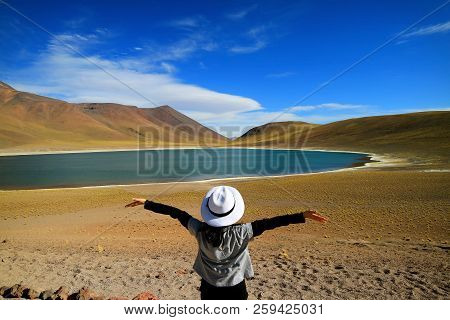 Female Tourist Raising Her Arms Admiring The Amazing Deep Blue Lagoon Laguna Miniques, Located In Th