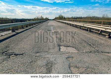 Old Broken Concrete Road Across The River By Car Bridge