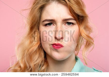 Facial Expression. Quizzical Grumpy Thoughtful Woman. Young Beautiful Blond Girl Portrait On Pink Ba