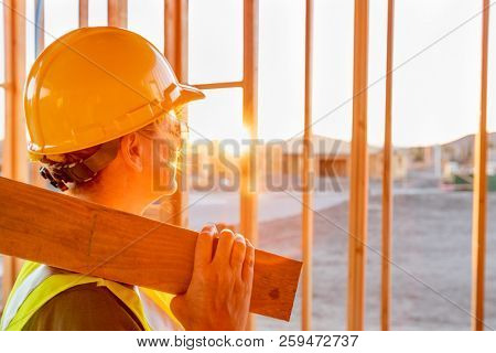 Female Construcion Worker Looking Out From New Home Framing