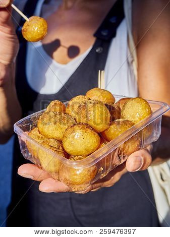 A Female Hand Holding A Box Of Lokma, Typical Turkish Fritter.
Also Know As Arabic Loqma Or Luqaimat