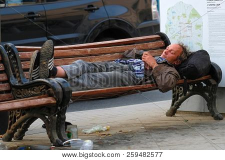 Mosocw, Russia - September, 10, 2018: homeless man sleeps on a bench on Moscow street