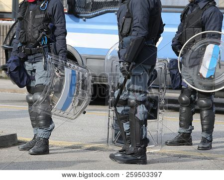 Many Policemen In Uniform During A Riot In The City With Shields