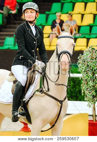 Beautiful Girl And Horse In Jumping Show, Equestrian Sports. Isabelline Akhal-teke Mare With Blue Ey