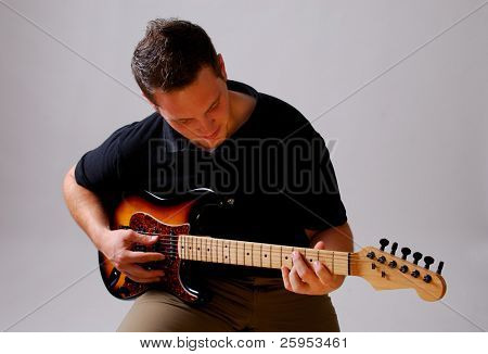 Jonge musicus spelen een oudere stijl Lead gitaar, geïsoleerd op een grijze achtergrond