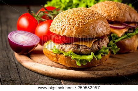 Close-up Photo Of Home Made Hamburger With Beer Made Of Beef, Onion, Tomato, Lettuce, Cheese And Spi