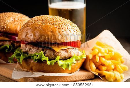 Close-up Photo Of Home Made Hamburger With Beer Made Of Beef, Onion, Tomato, Lettuce, Cheese And Spi