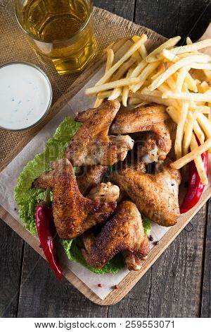 Close-up Photo Of Bbq Chicken Wings With Fries And Beer. Barbeques Meat With Sauces, Ketchup, Mayonn