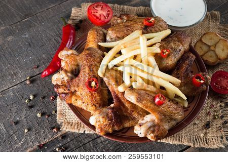 Close-up Photo Of Bbq Chicken Wings With Fries And Beer. Barbeques Meat With Sauces, Ketchup, Mayonn