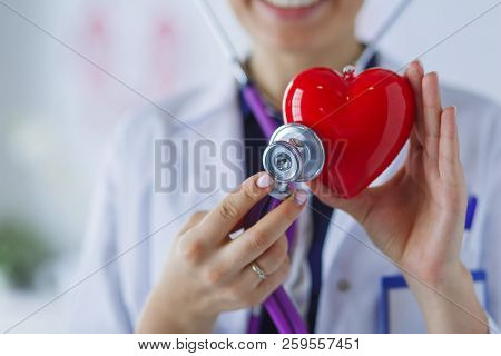 A Doctor With Stethoscope Examining Red Heart, Isolated On White Background