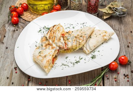 Shawarma Sandwich Or Lavash With Fresh Vegetables And Sauce On The Gray Plate Decotated With Cherry 