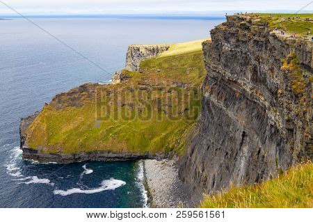 People Walking Over Cliffs Of Moher
