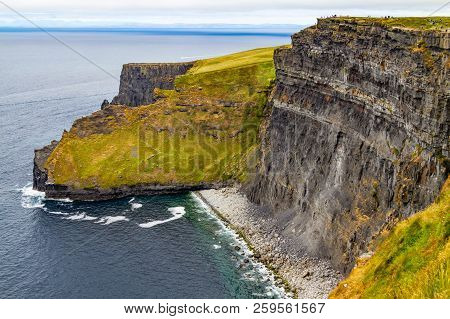 People Walking Over Cliffs Of Moher