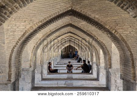 Isfahan, Iran - August 7, 2016 : Iranian Youngsters Gathering Under Kahju Bridge, One Of The Main Br
